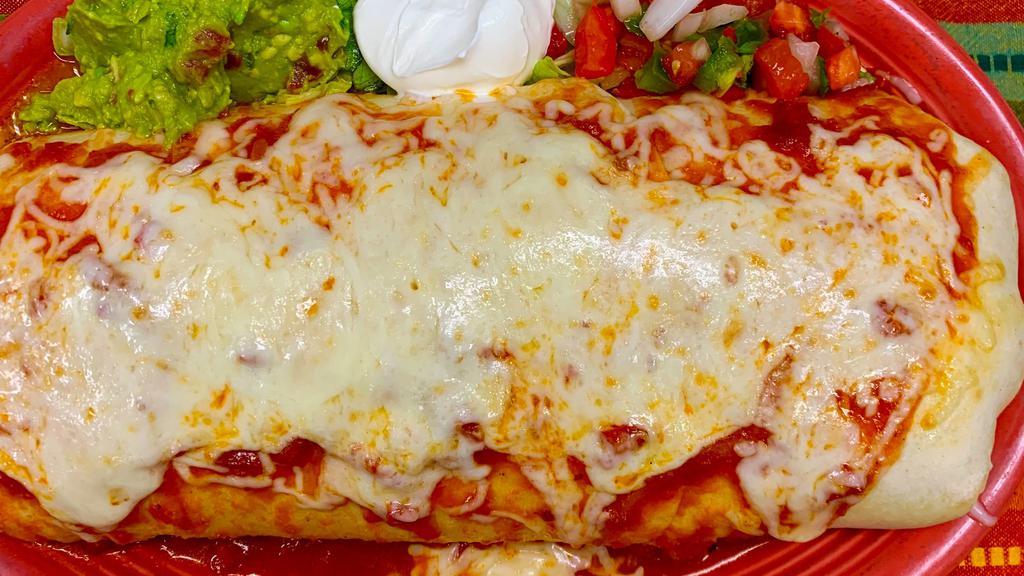 Burrito Grande · Beef, chile verde, chicken, rice and beans inside 3 large flour tortillas, smothered with espana sauce and melted cheese