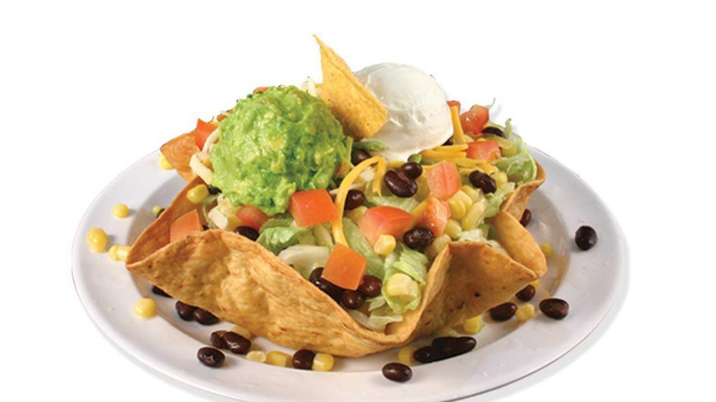 Sureño Taco Salad · Tortilla shell with refried beans, choice of meat, lettuce, onions, cheese, corn, guacamole, sour cream, black beans, salsa, tomatoes.