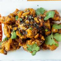 Cracklin' Spicy Cauliflower · Fried sesame tempura battered cauliflower tossed in a Spicy Black Bean sauce. Topped with gr...