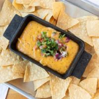 Caliente Queso Dip & Chips · Cheddar, jack & pepper jack cheese, simmered with roasted jalapeños, onion and tomatoes. Ser...