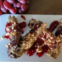 Pbj Crispy Ribs · Our signature crispy ribs tossed in a peanut butter glaze and topped with grape jelly and ch...