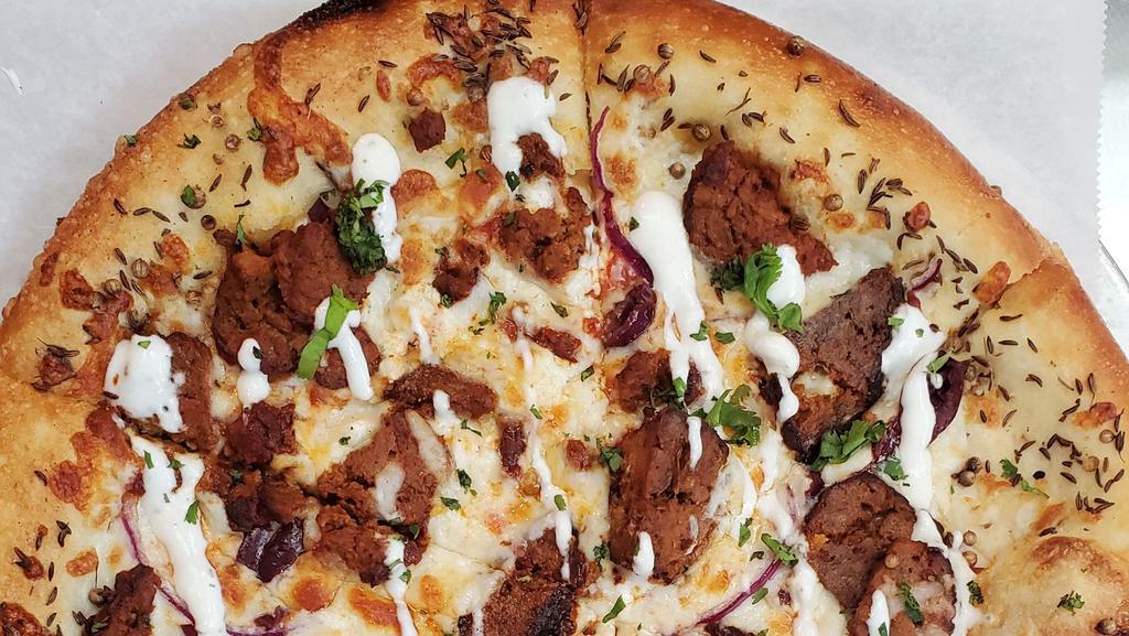 Moroccan Meatball Pizza · Our Famous Meatballs, Goat Cheese, Mozzarella, Onions, Olives, Harissa Tomato Sauce, Moroccan Spiced Crust.  Topped with Tzatziki and cilantro.