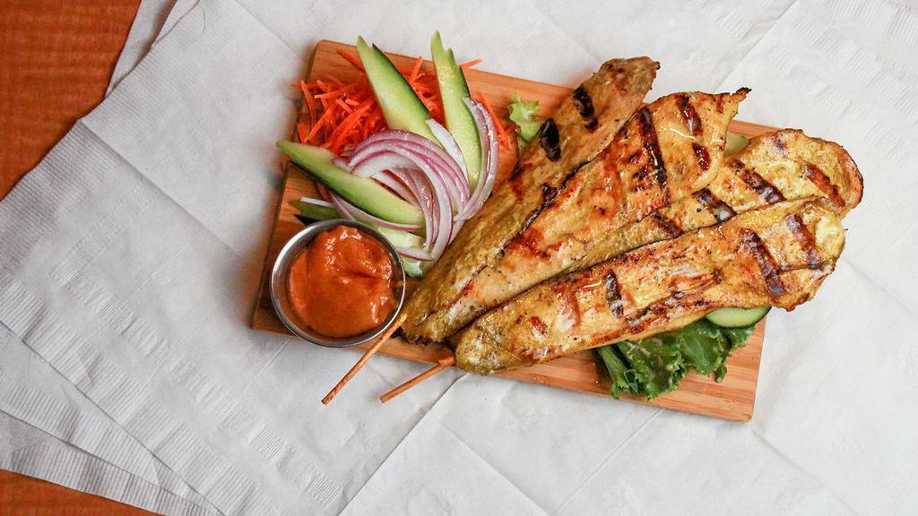 Chicken Satay (4) · Marinated grilled chicken skewers served with peanut sauce and small cucumber salad.