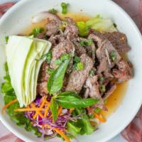 Nuea Num Tok (Grilled Beef Salad) · Grilled beef salad mixed with red and green onions, roasted rice, mint, cilantro, lettuce, d...