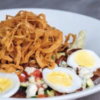 The Chopped Salad · A bed of chopped iceberg lettuce with haystack onions, bacon crumbles, tomato, hard-boiled e...