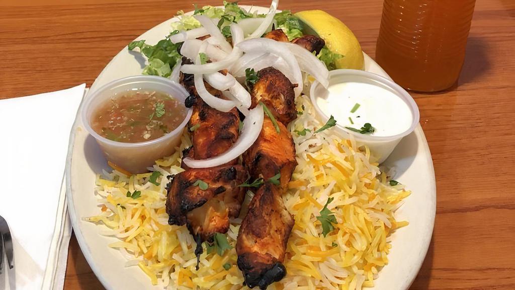 Chicken Kabob Platter · White meat chicken cubed and served with basmati rice, topped with parsley and salad.