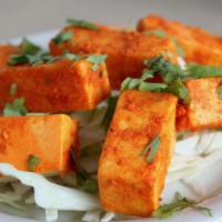 Tandoori Paneer · Home-made cheese in a tandoori marinade with red chili and coriander tossed with roasted cum...