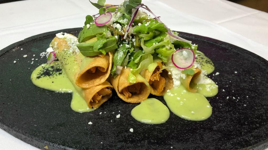 Flautas De Pollo · Deep-fried homemade tortillas rolled with chicken, topped with guacamole sauce, lettuce, tomato, sour cream, and cotija cheese