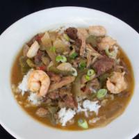 Gumbo · A stew of dark roux, okra, bell pepper, chicken, andouille sausage, and shrimp over rice. Se...