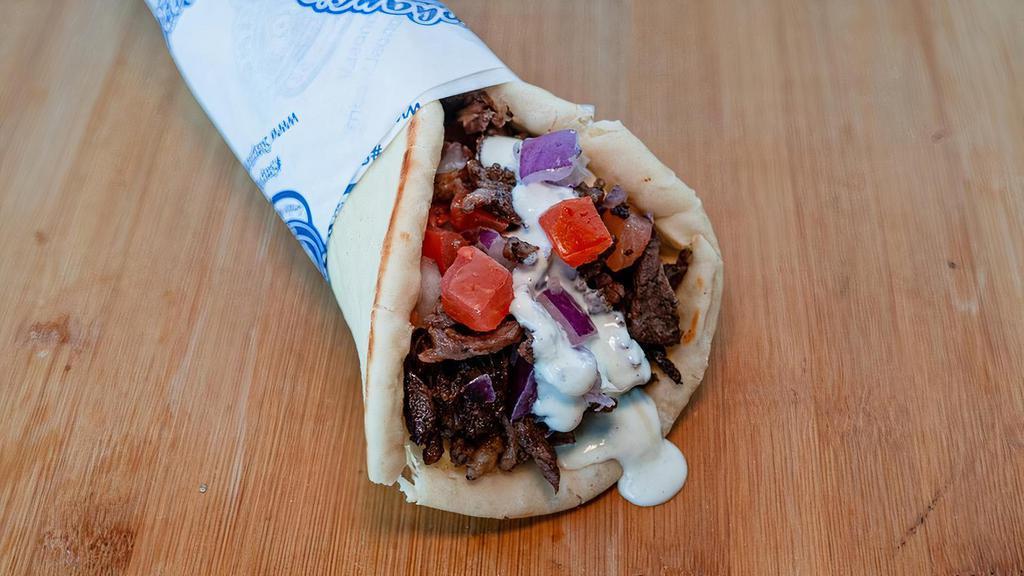 Beef Gyro Wrap · Slices of beef wrapped in pita bread with tomatoes, red onions, garlic sauce and tzatziki sauce.