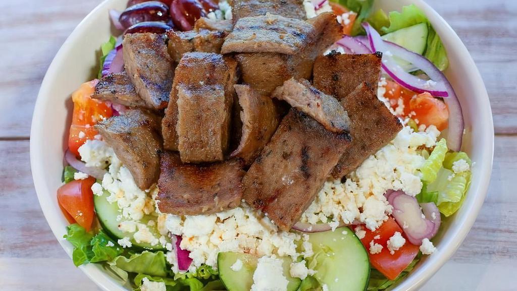 Beef & Lamb Gyro Salad · Served with lettuce, tomatoes, onions, cucumbers, feta cheese, olives, tzatziki sauce and pita. Topped with sliced Gyro.