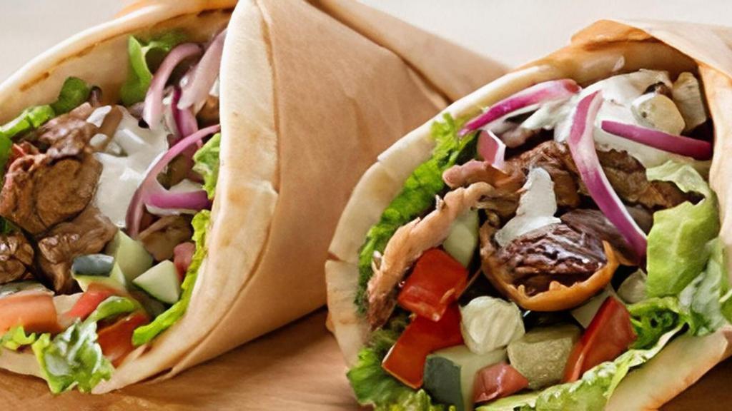 Traditional Gyro · Garbanzo Way includes: romaine lettuce, gyro meat, tzatziki sauce, sliced tomatoes, pickled onions, and feta cheese. .