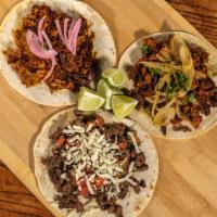 Three Tacos Campechanos · Soft corn tortillas, guacamole, steak and chorizo, topped with caramelized onions and cilant...