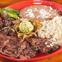 Carne Asada · Seasoned skirt steak, garnished with grilled onions and guacamole.