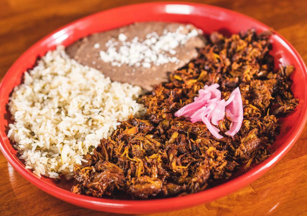 Cochinita Pibil · Slow-roasted pork dish cochinita involves marinating the meat in strong acidic citrus juice, seasoning it with annatto seed which imparts a vivid burnt orange color, and roasting the meat while it is wrapped in a banana leaf.