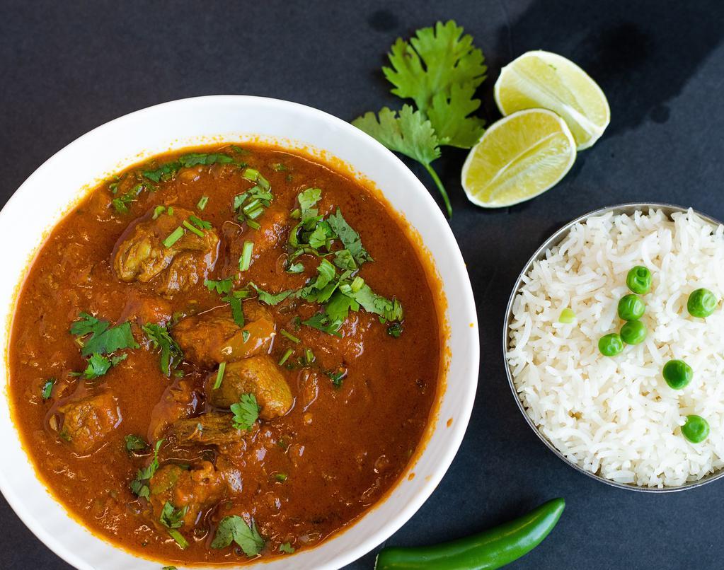 Goat Curry (Mutton Curry) · Slow cooked traditional bone-in meat with onions, tomatoes, ginger, garlic and aromatic spices.