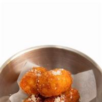 Cheesy Tots · Deep fried potato tots filled with our signature three cheese blend, topped with Parmesan an...