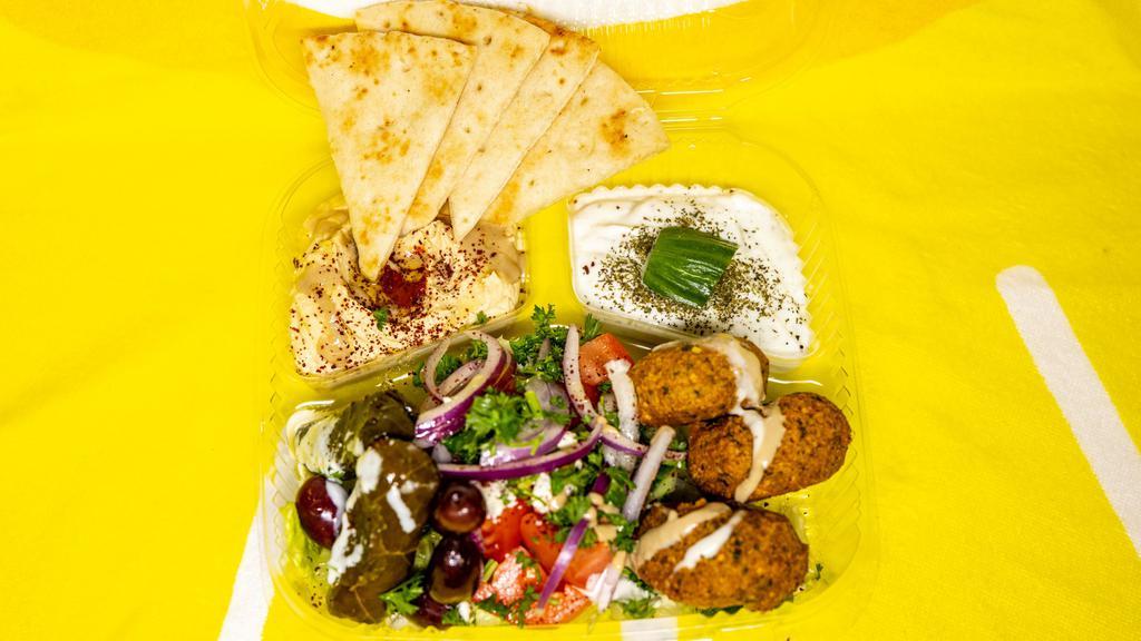 Maza Appetizers Sampler (Veggie) · Three pieces of falafel, two dolmades, hummus, baba ghanouj, Greek feta salad and pita bread.