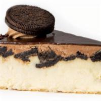 Oreo Cheesecake Slice · Creamy New York cheesecake with chunks of Oreo cookies iced in chocolate buttercream and pou...