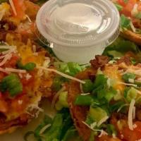 Potato Skins · Potato skins loaded with bacon, melted cheddar, tomatoes, green onions and sour cream.