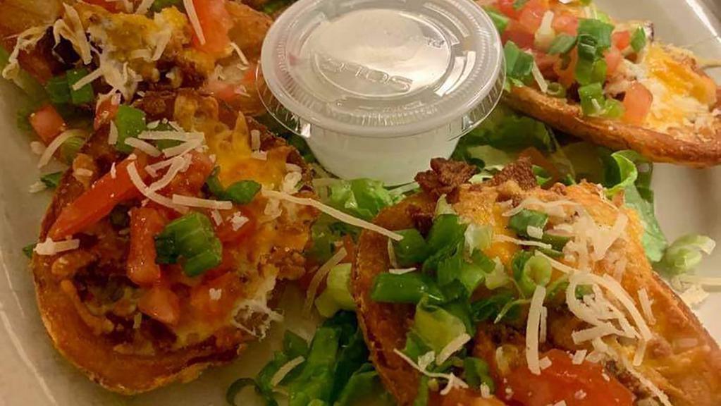 Potato Skins · Potato skins loaded with bacon, melted cheddar, tomatoes, green onions and sour cream.