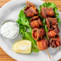 Bacon-Wrapped Scallops · Crispy bacon wrapped around tasty scallops. Served with aioli sauce and fresh lemon.