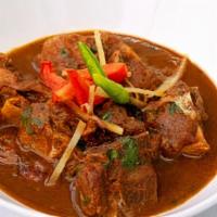 Goat Curry · All meals come with naan bread, and a side of pickles and onions slowly cooked goat meat in ...
