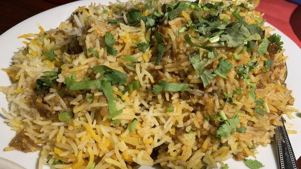 Chicken Biryani · Our long grain basmati rice cooked with chicken marinated in yogurt and house spices fresh vegetables and chicken in our special biryani masala gravy, served with a side of yogurt raita.