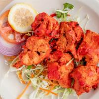 Chicken Tikka · Chicken breast marinated in yogurt and spices, cooked in tandoor, and served over a bed of b...