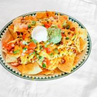 Super Nachos · Corn tortilla chips topped with refried beans, guacamole. sour cream, green onions, tomatoes...