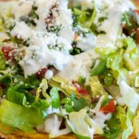 Tostada · Crunchy corn tortilla, cheese, refried beans, choice of meat, lettuce and pico de gallo.