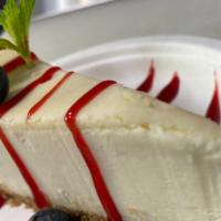 Traditional Cheese Cake · 1 Pc cheese cake with raspberry sauce and strawberries.