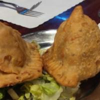 Vegetable Samosa · Vegan. A savory fritter filled with potatoes and peas, delicately flavored with spices.