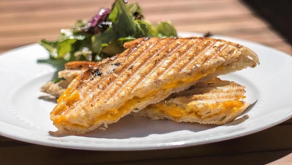 Vegan Grilled Cheese Panini · Vegan cheddar on crispy sourdough bread brushed with herbs and olive oil. Served with choice of chips, side salad w vegan dressing or fruit.