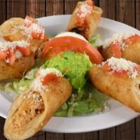 Chicken Taquitos · Crisp flour tortillas topped with fresh, tasty chicken on a bed of lettuce, garnished with s...