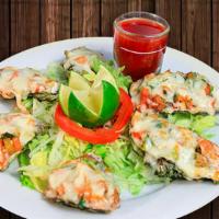 Ostiones A La Michelada · Oysters in their shell obaked in Michelada sauce with pico de gallo and omelted Monterey Jac...