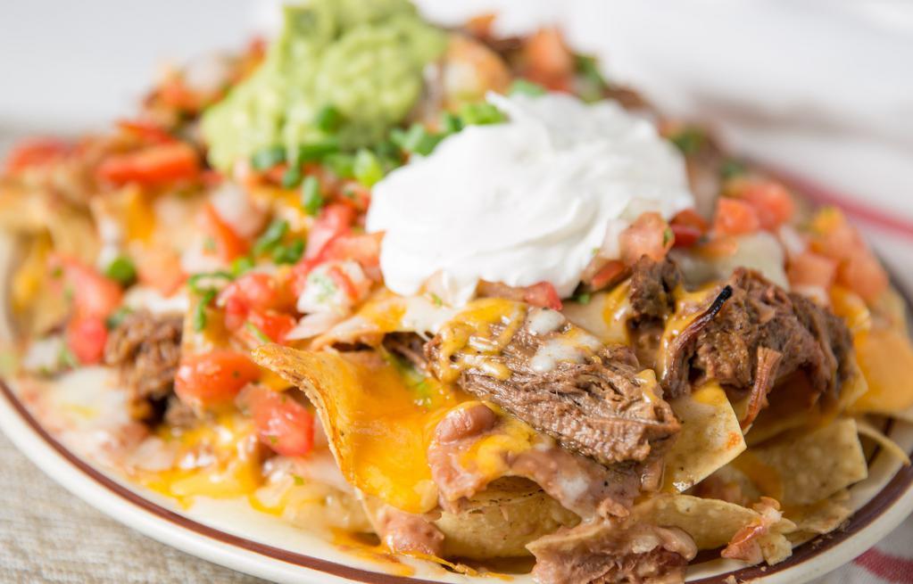 Nacho Supreme · With beef, chicken or pork with beans, cheese, sour cream, guacamole and salsa fresca.