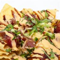 Poke Nachos · Ahi tuna on a bed of chips, topped with diced jalapenos, green onion, and cilantro. Drizzled...