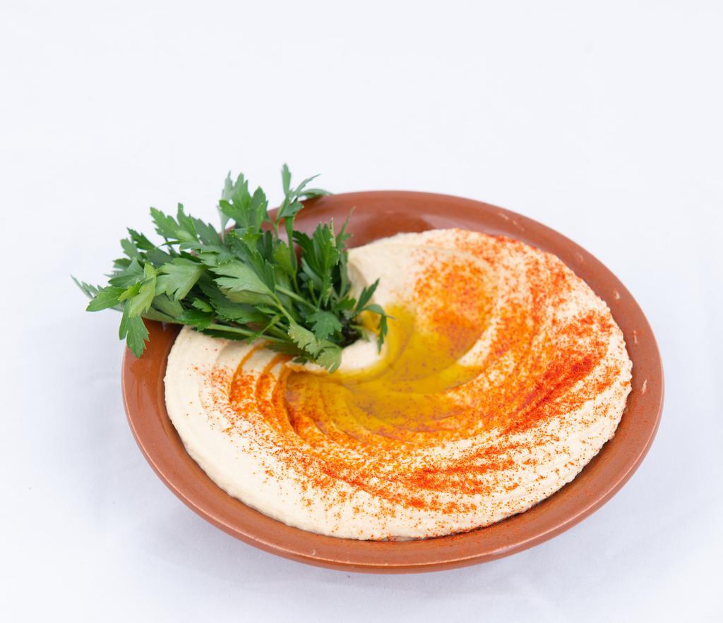 Hummus · Pureed chickpeas blend with sesame tahini paste and lemon juice served with pita bread.
