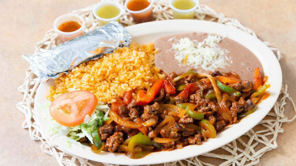 Steak Ranchero · Chopped beef steak meat sautéed with bell pepper, tomatoes and onions and a spicy yet sweet sauce. Served with a side of rice, beans and a side of tortillas.