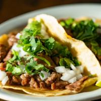 Taco · Street-style taco with cilantro and onion. Lime and salsa on the side, build it how you want...