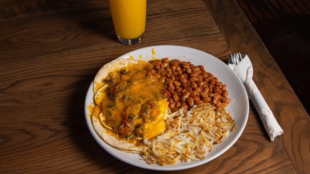 Huevos Rancheros · 2 fried eggs on top of corn tortillas smothered with cheese and your choice of chile. Comes with pinto beans and traditional style hash browns.