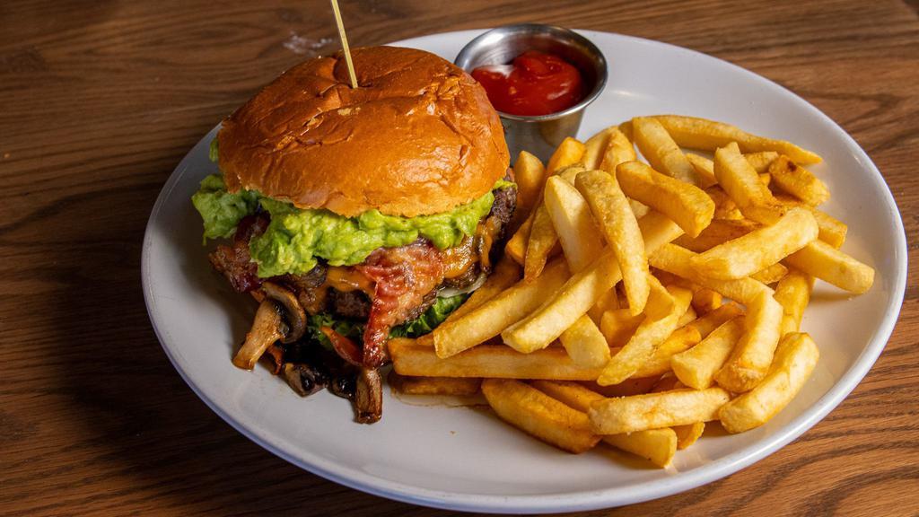 Deluxe Burger · Avocado spread, bacon, grilled mushrooms and onions, cheddar cheese, lettuce, tomato and signature sauce. Add green chile for an additional charge.