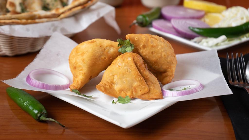 Samosa · A delectable duo of handmade crisp cones filled with potatoes, peas, cumin, spiced, and seasoned. Served with house special tamarind and mint chutney.