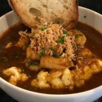 Shrimp & Grits · Gulf prawn, Cajun butter, tomato, crispy shallot, chive, and toasted rustic bread.