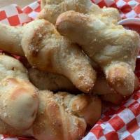 Garlic Knots* · Fat Daddy's signature pizza dough tied into knots, baked crispy soft and topped with garlic ...