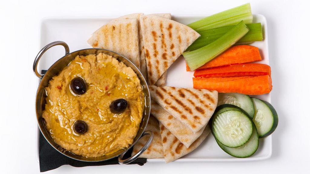 Signature Warm Hummus · Our signature warm hummus is made in house with roasted red peppers, Kalamata olives and feta served with warm pita and vegetables.