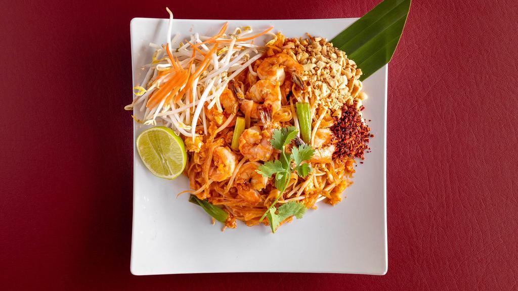 Pad Thai · Stir-fried thin rice noodles with pad Thai sauce, meat, bean sprouts, green onions and egg. Topped with ground peanuts and a slice of lime and cilantro.