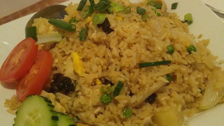 Pineapple Fried Rice · Stir-fried jasmine rice with meat, egg, onions, pineapple, cashew nuts and raisins.