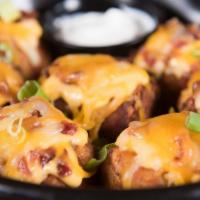 Totchos · Our jumbo tater tots stuffed with serrano peppers, bacon, and cheddar. Topped with bacon, gr...